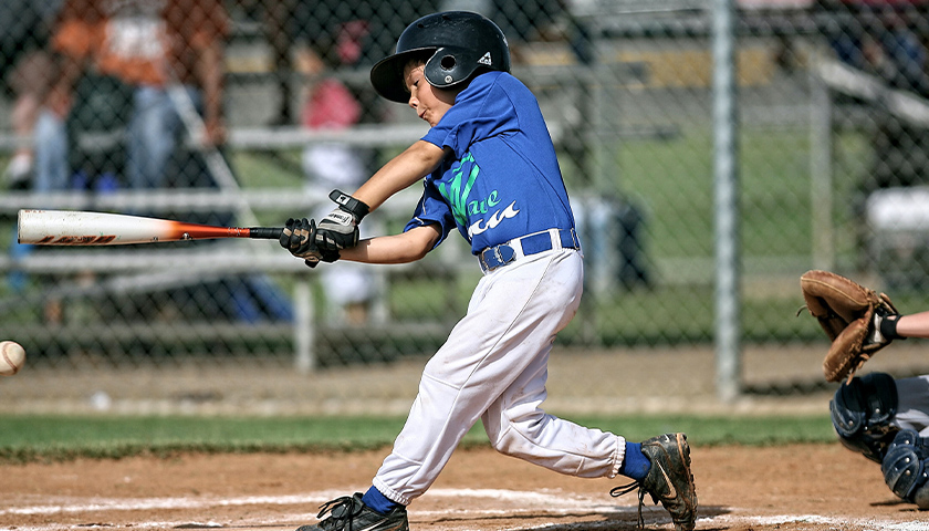 Young boy hitting a baseball