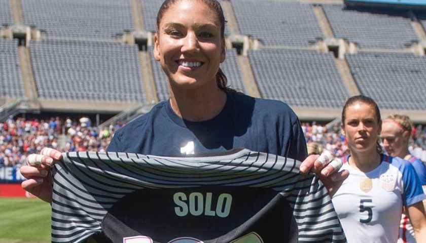 Hope Solo holding up jersey