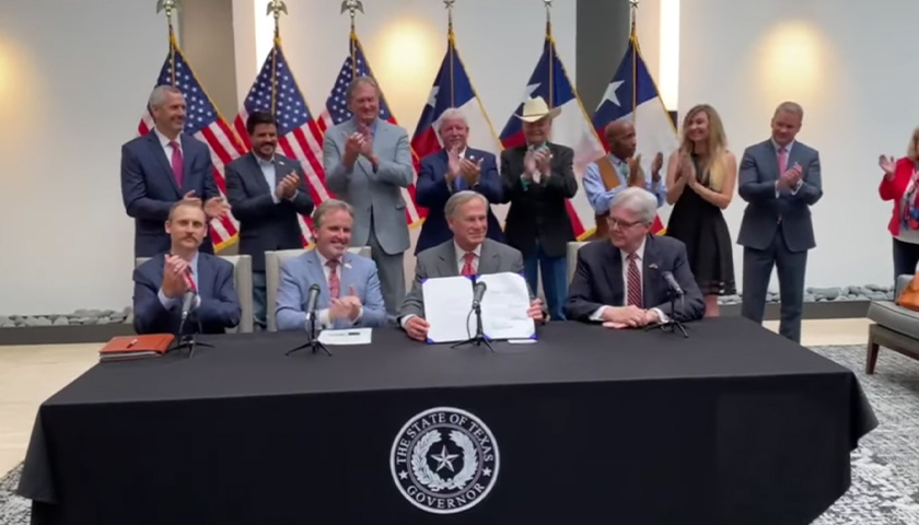 Greg Abbott holding recently signed Texas voting reform bill