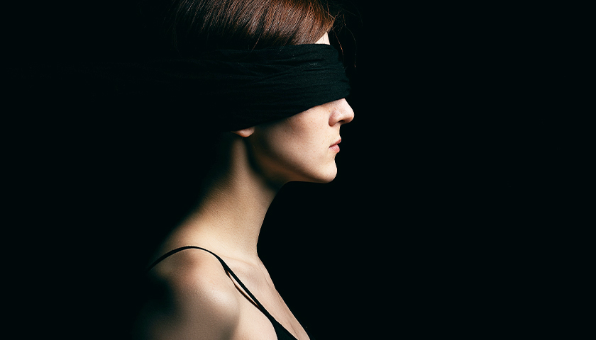 brunette woman with a blindfold on